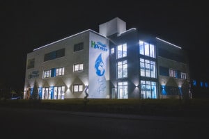 Firmenansicht H.Preiss International WATER WORLD bei Nacht. Man sieht eine Welt in einem Wassertropfen mit der Schrift Trink was Reines darunter